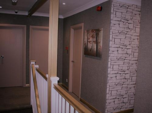 Habitación con pared de piedra y escalera. en White Rose Hotel and Restaurant en Leeds