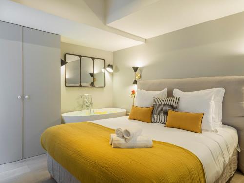 une chambre avec un grand lit avec une couverture jaune dans l'établissement Fabulous Grey, à Paris