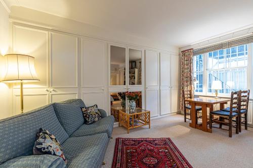 ロンドンにあるAttractive 2BR flat in Little Venice, Maida Valeのリビングルーム(青いソファ、テーブル付)