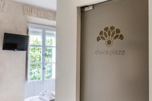 a sign on a wall in a room with a window at Hotel Boutique Elvira Plaza in Seville