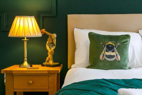 a bedroom with a bed with a pillow with a bee on it at The Mayfield Apartments in Sunderland