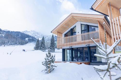 a wooden house in the snow with a mountain at Alpenchalets Biberwier Zugspitze by ALPS RESORTS in Biberwier