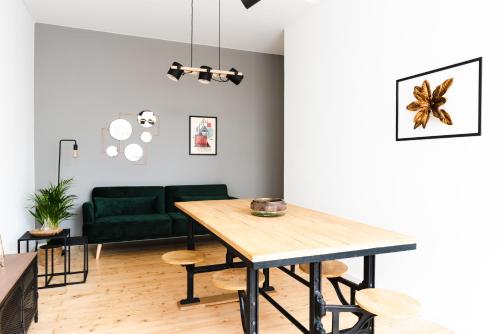 een woonkamer met een tafel en een groene bank bij 4-Zi Urban Design 120m² BRANDNEW 200Mbit in Berlijn
