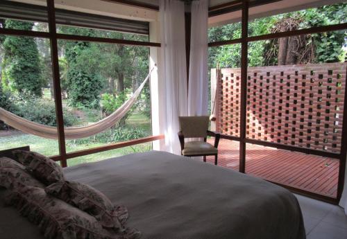 ein Schlafzimmer mit einem Bett und ein Fenster mit einer Hängematte in der Unterkunft Casa Las Margaritas in Mar del Plata