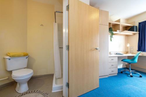 a bathroom with a toilet and a desk and a chair at For Students Only Private Bedrooms with Shared Kitchen at Shaftesbury Hall in the heart of Cheltenham in Cheltenham