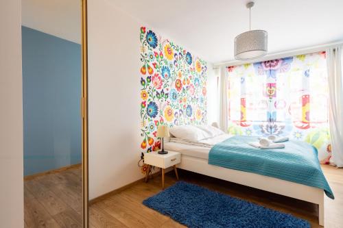 um quarto com uma cama com um tapete azul e uma janela em Apartments Kremer Cracow em Cracóvia