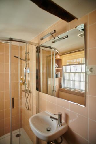 a bathroom with a sink and a shower with a mirror at Casa da Praça Velha Guest House in Braga