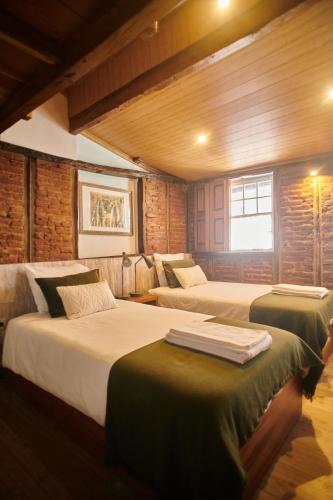 a bedroom with two beds and a window at Casa da Praça Velha Guest House in Braga