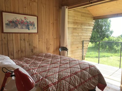 a bedroom with a bed in a room with a window at Cabaña Eco Loft Chiloe Chonchi in Chonchi