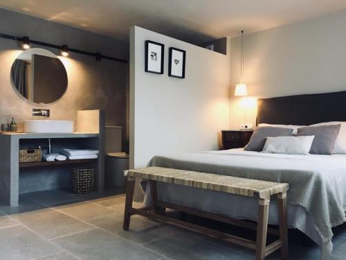a bedroom with a bed and a mirror and a bench at CAN SAFRA in La Pera