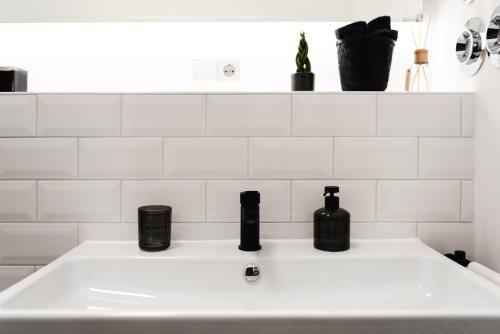 a white bathroom sink with three bottles on it at 4-Zi Urban Design 120m² BRANDNEW 200Mbit in Berlin