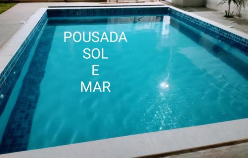 a swimming pool with a sign that reads pussada sodium e mar at Pousada Sol e Mar Cabo Frio in Cabo Frio