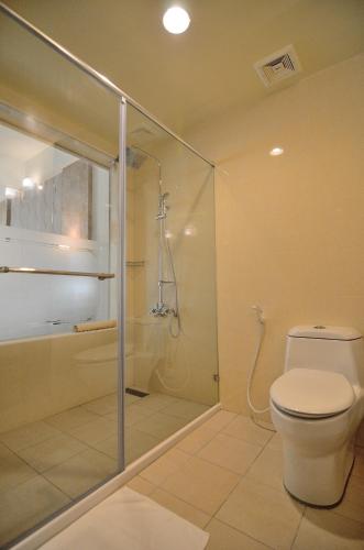 a bathroom with a toilet and a glass shower at Royal Chiayi Hotel in Chiayi City