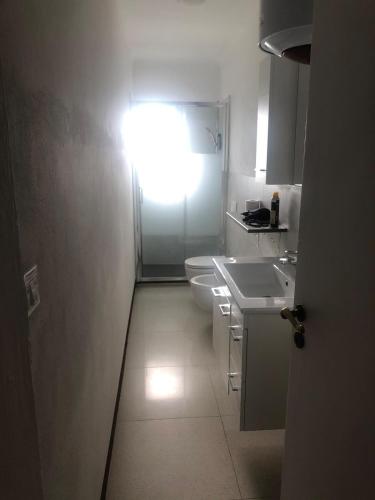 un bagno bianco con un water e un lavandino di MyRoom sui Portici a Bologna