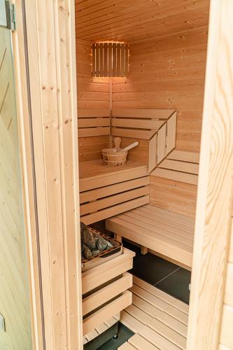 a wooden sauna with a basket in the middle at Jeżowa Woda Ośrodek Wypoczynkowy Palmiarnia i SPA in Przyszowa