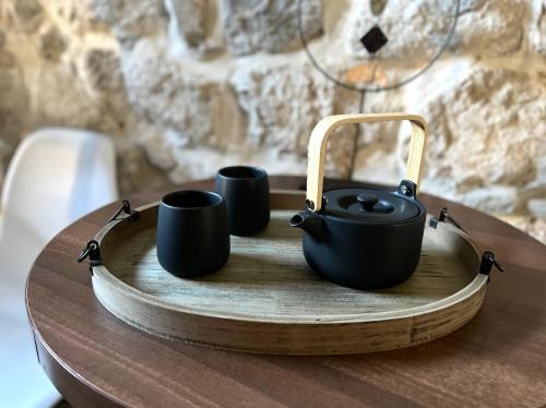 a tea pot and two cups on a wooden table at HealthyStudio512 Apartments in Kotor