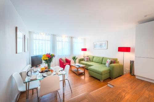a living room with a green couch and a table at Highland Apartments by Mansley in Inverness