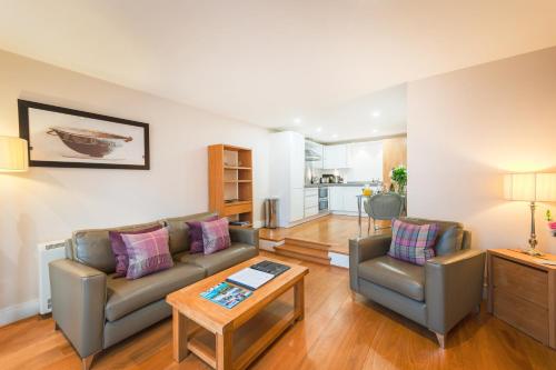 a living room with a couch and a table at Highland Apartments by Mansley in Inverness