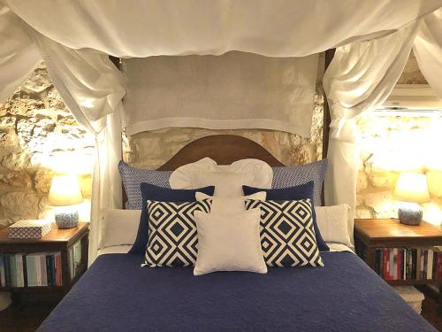 a bedroom with a bed with blue and white pillows at Lalla Luxury Villa in Lithakia