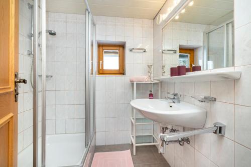 a white bathroom with a sink and a shower at Laubichlhof in Flachau