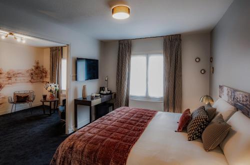 a hotel room with a bed and a television at Hôtel Quorum in Saint-Cloud