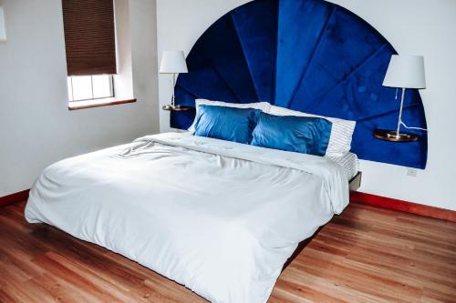 um quarto com uma cama grande e uma cabeceira azul em Renovated building in the heart of Rapid City! em Rapid City