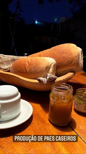 a table with a loaf of bread and a jar of sauce at Topo do Cipó Ecopousada Vegana in Serra do Cipo