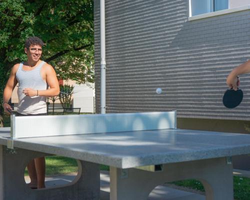 a man standing next to a ping pong table at Nyon Hostel in Nyon