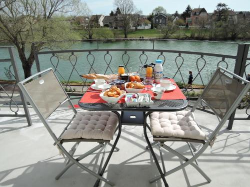 馬恩河畔勒佩赫的住宿－LES PINGOUINS DE LA MARNE，一张桌子,上面有食物,还有两把椅子