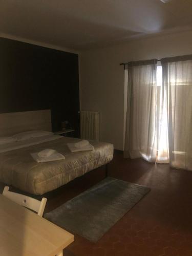 a bedroom with two beds and a window with curtains at MyRoom sui Portici in Bologna