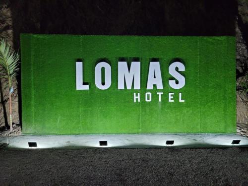 a green sign with the words lomas hotel at Lomas Hotel in San José de Ocoa