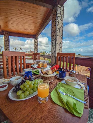 Ein Tisch mit einem Teller Obst und Saft auf einer Terrasse in der Unterkunft Pousada Bella Mar in Prea