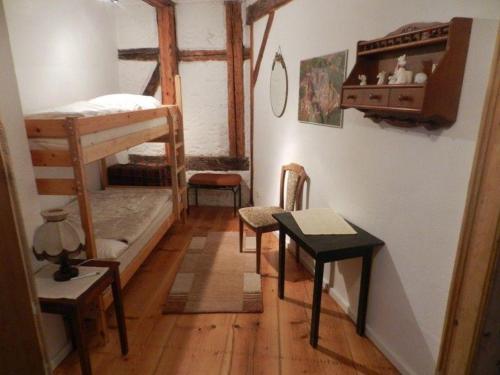 una habitación con dos literas y una mesa en Ferienwohnung-Kutscherhaus, en Wernigerode
