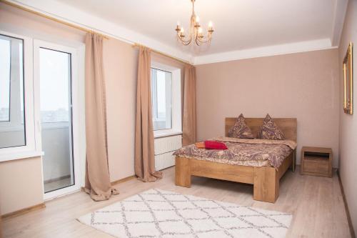 a bedroom with a bed and two windows at 2 Rooms Luxury Apartment on Shkilna 34 Street in Zaporozhye