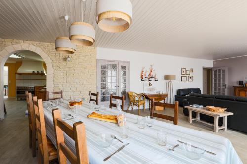 une salle à manger et un salon avec une grande table dans l'établissement Charmante maison pour 10 personnes, au Bois-Plage-en-Ré