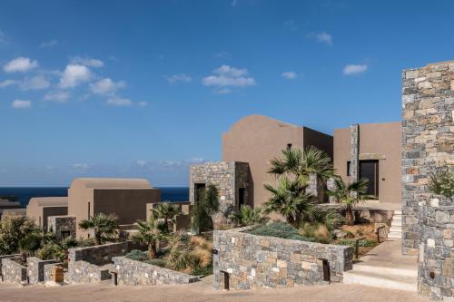 - une façade extérieure avec des palmiers dans l'établissement Acro Suites - A Wellbeing Resort, à Agia Pelagia