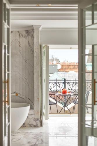 a bathroom with a tub and a view of a balcony at The Cadogan, A Belmond Hotel, London in London