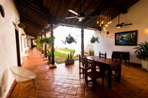 a dining room with a table and chairs and plants at Bohemia Hotel Boutique in Mompos
