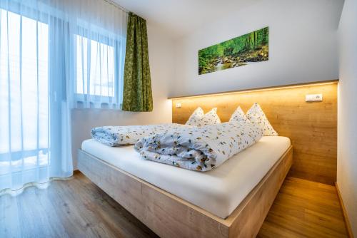 1 dormitorio con 1 cama con sábanas y almohadas blancas en WiWa Appartement, en Flachau