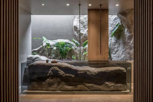 a large aquarium with a large rock in a room at Acro Suites - A Wellbeing Resort in Agia Pelagia