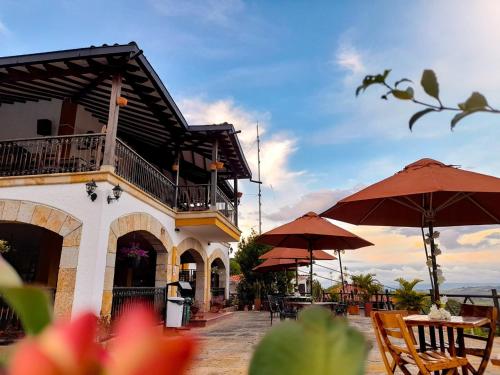 a building with umbrellas and tables and chairs at Hotel Las Rocas Resort Villanueva in Villanueva