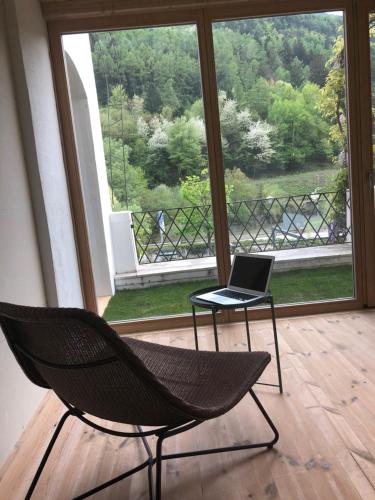 a chair and a laptop on a table in front of a window at Botango in Parcines
