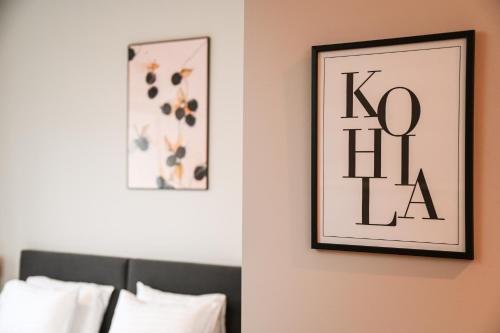 a bedroom with two framed pictures on the wall at Tohi Distillery apartments in Kohila
