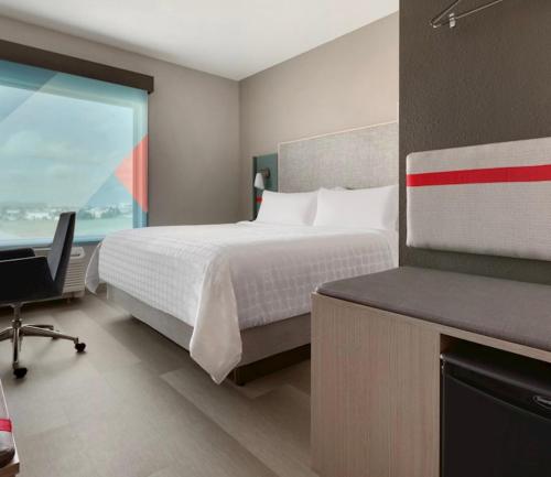 a bedroom with a bed and a desk and a window at avid hotels - Macon North by IHG in Macon