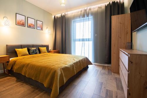 a bedroom with a bed and a large window at Schneidemühl Premium Apartments in Piła