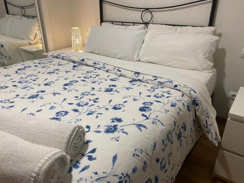 um quarto com uma cama com um edredão azul e branco em Madrid Airport Apartments em Madri