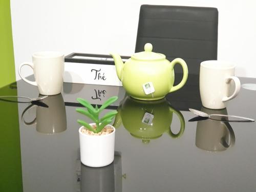 a green tea pot and cups on a wall at Appartement entier meublé à Beaumont proche Futuroscope et Poitiers Technopole in Beaumont