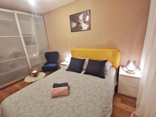 une chambre avec un lit et une chaise bleue dans l'établissement Le calme du Sentier - Marne, à Noisy-le-Grand