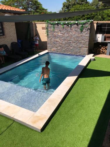 a man is standing in a swimming pool at Alquiler San Bernardino Altos Loma grande in Loma Grande
