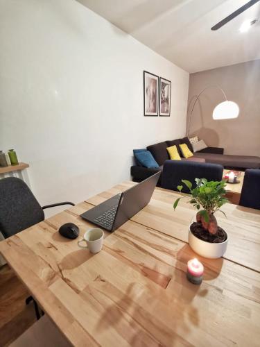 - un salon avec une table en bois et un ordinateur portable dans l'établissement Le calme du Sentier - Marne, à Noisy-le-Grand